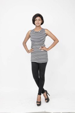 Siyah-beyaz çizgili kolsuz bluz, siyah kot, beyaz arka planda yüksek topuklu, moda, güzellik, kendine güven için ideal, minimal stil..