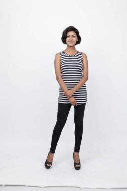 Siyah-beyaz çizgili kolsuz bluz, siyah kot, beyaz arka planda yüksek topuklu, moda, güzellik, kendine güven için ideal, minimal stil..