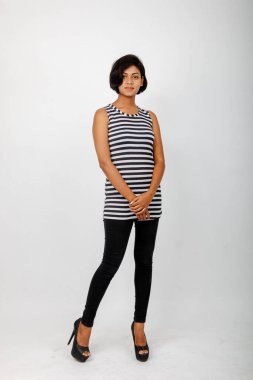 Siyah-beyaz çizgili kolsuz bluz, siyah kot, beyaz arka planda yüksek topuklu, moda, güzellik, kendine güven için ideal, minimal stil..