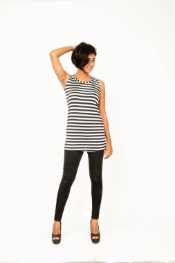 Siyah-beyaz çizgili kolsuz bluz, siyah kot, beyaz arka planda yüksek topuklu, moda, güzellik, kendine güven için ideal, minimal stil..