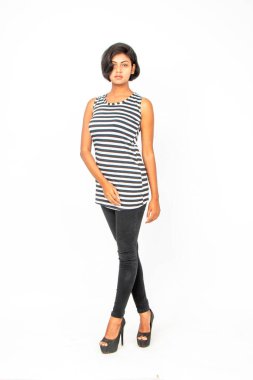 Siyah-beyaz çizgili kolsuz bluz, siyah kot, beyaz arka planda yüksek topuklu, moda, güzellik, kendine güven için ideal, minimal stil..