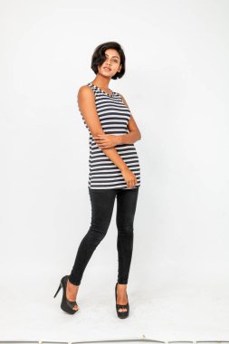 Siyah-beyaz çizgili kolsuz bluz, siyah kot, beyaz arka planda yüksek topuklu, moda, güzellik, kendine güven için ideal, minimal stil..