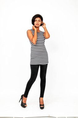 Siyah-beyaz çizgili kolsuz bluz, siyah kot, beyaz arka planda yüksek topuklu, moda, güzellik, kendine güven için ideal, minimal stil..