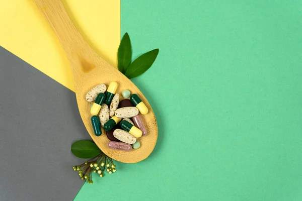 Kruidenpillen Een Houten Lepel Met Kruiden Gekleurde Achtergronden Andere Vitaminen — Stockfoto