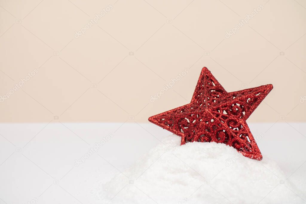 Red Christmas star, partly one side in the snow.