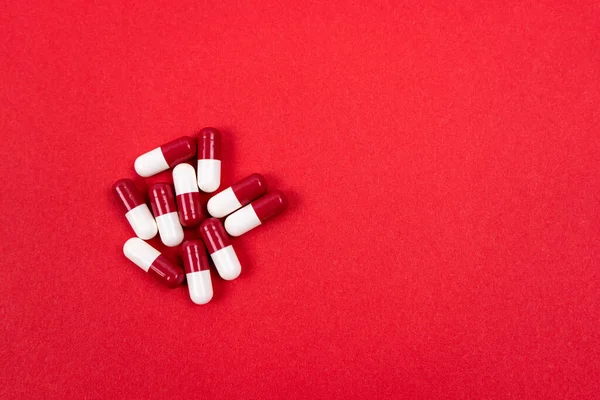 Rode Witte Capsules Een Rode Achtergrond Gezondheidszorg Concept Kopieerruimte — Stockfoto