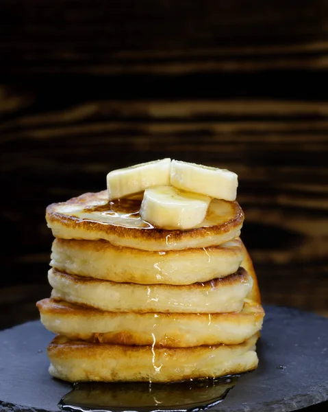 Deliciosas panquecas douradas frescas com pedaços de banana, secas com mel — Fotografia de Stock