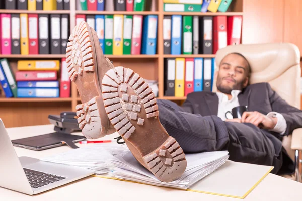 Уставший африканский мужчина спит в офисе — стоковое фото
