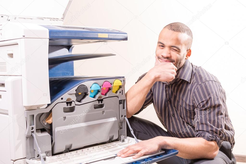 Smiling technician sitting near copier — Stock Photo © pbophotogpapher
