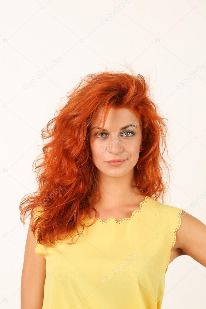 portrait of smiling redhead young woman in yellow dress