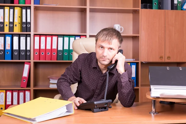 Homme au bureau parlant au téléphone — Photo