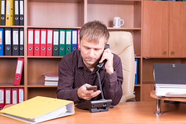 Homme avec des docs au bureau parlant au téléphone — Photo