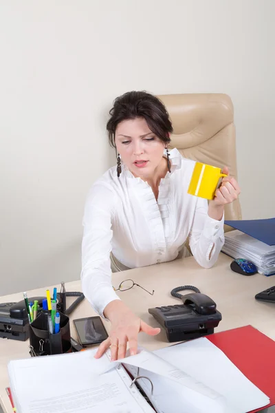 Mujer preocupada con taza en la oficina — Foto de Stock