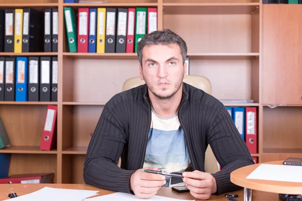 Homme non rasé au bureau avec stylo — Photo