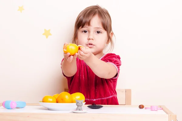 küçük sevimli küçük kız ve mandarin