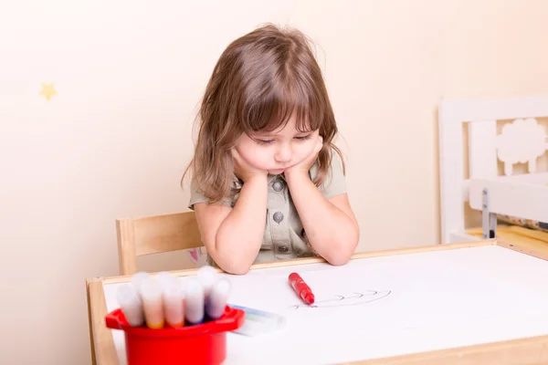 Okulda masa başında oturan üzgün küçük kız