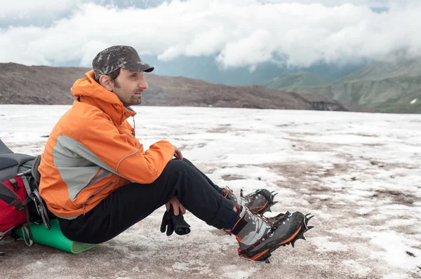 yorgun alpinist sırt çantası üzerinde oturan