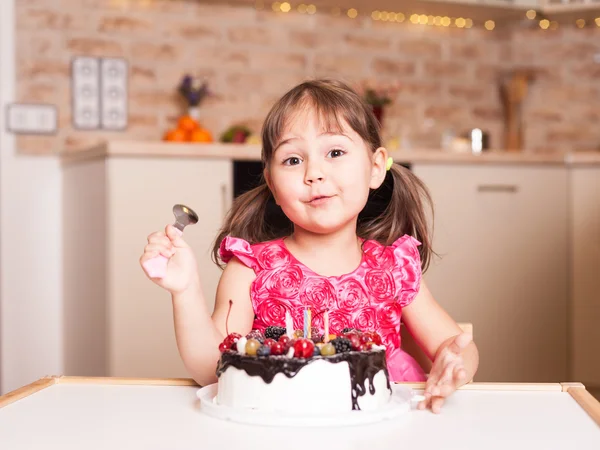 surprised little girl with cake and spoon
