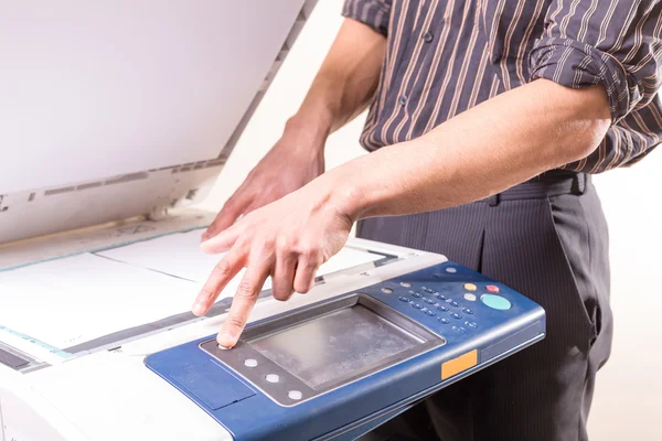 belgelerin kopyalarını yapmak için Fotokopi makinesi kullanan adam