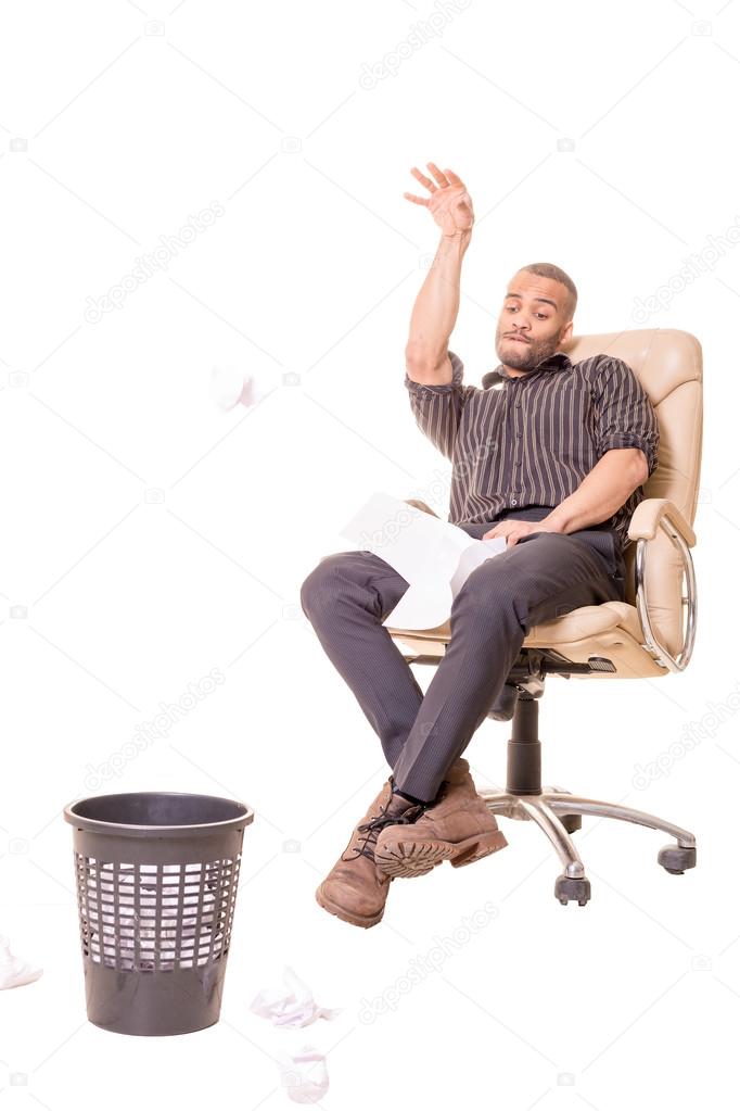 african man sitting in chair and playing basketball with rubbish