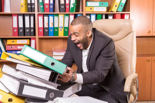 Hombre en la oficina con un montón de papeleo aburrido — Foto de Stock