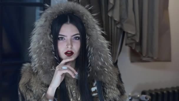 Beautiful brunette in fur coat posing on camera — Stock Video