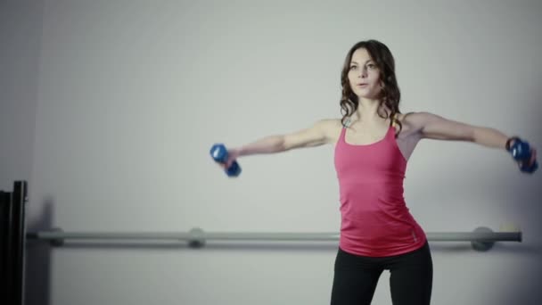 Hon arbetar med en hantel på gymmet — Stockvideo