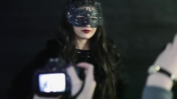 Chica fotografiada en una máscara sobre un fondo negro — Vídeos de Stock