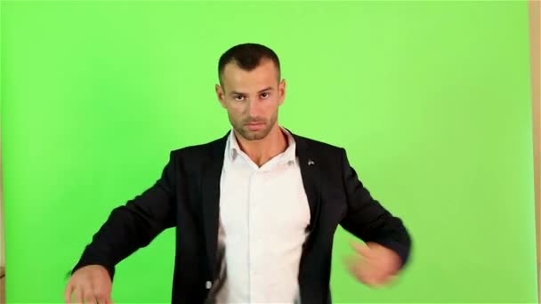 Чоловік носить куртку на зеленому тлі — стокове відео