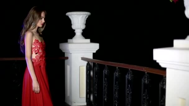 Vacker flicka i en röd klänning på balkongen — Stockvideo