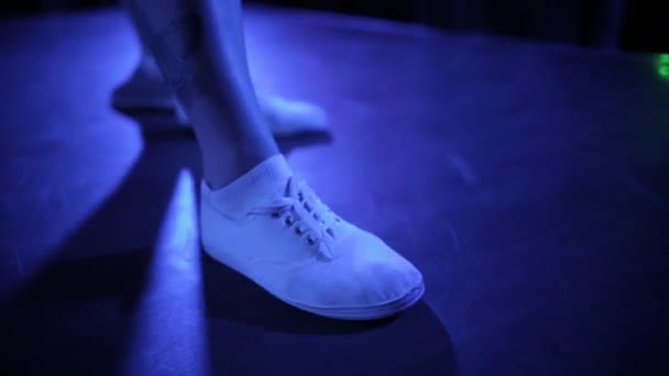 Benen van een danser met een tatoeage in witte schoenen op het podium van de Club — Stockvideo