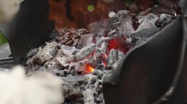 Demirci kömürlerin bir mangal ve at nalı taciz ateşi düzeltir