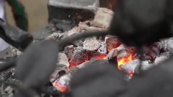 Smeden korrigerar kolen i en Brazier och trakasserande eld från Horseshoe — Stockvideo