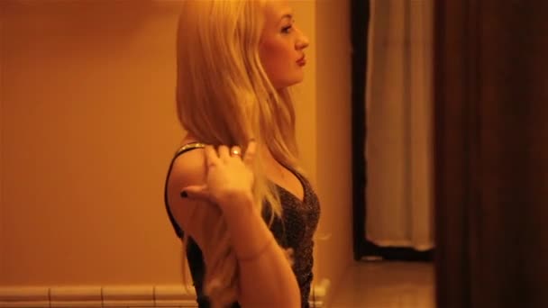 Blonde fille regarde le miroir et redresse les cheveux — Video