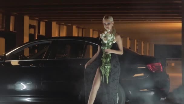 Mooie meisje in de buurt van een zwarte auto. — Stockvideo