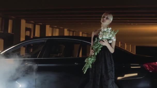 Mooie meisje in de buurt van een zwarte auto. — Stockvideo