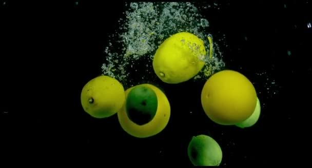 Citrusvruchten in water op een zwarte achtergrond — Stockvideo