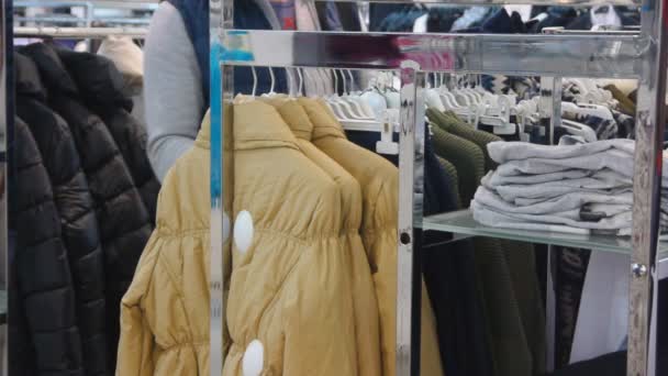 Mann som velger klær i butikken – stockvideo