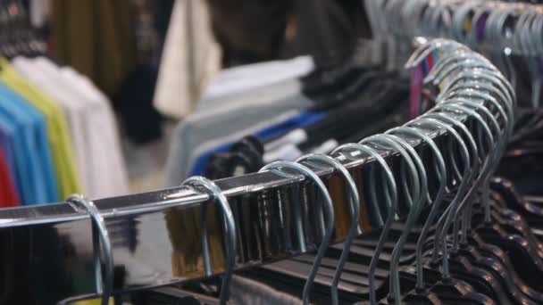 Kleding hangers close-up op de wazig achtergrond — Stockvideo