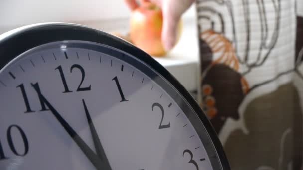 Tomando Apple detrás del reloj en la cocina — Vídeo de stock