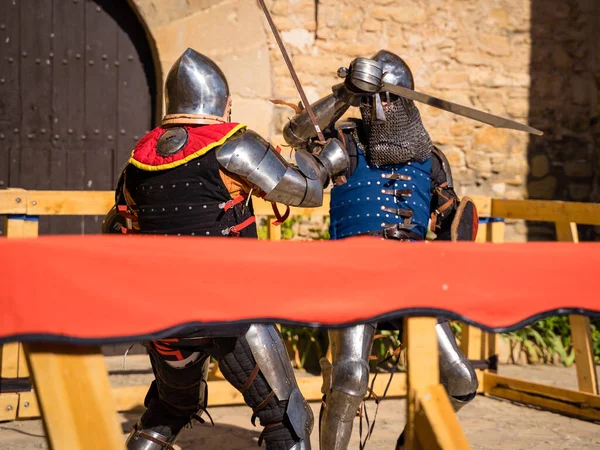 medieval knights dueling, blue knight attacking profight tournament in montonis castle lleida catalonia spain