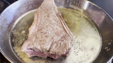 Sıcak yağlı tavada pişirilmiş büyük bir biftek. Yüksek kalite 4k görüntü