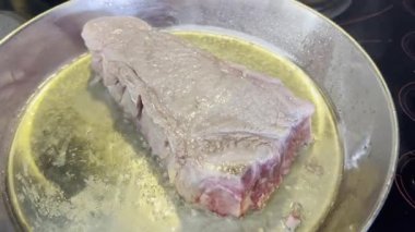 Sıcak yağlı tavada pişirilmiş büyük bir biftek. Yüksek kalite 4k görüntü