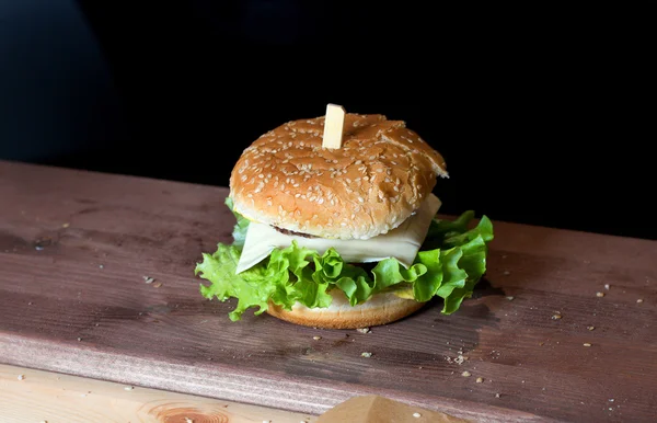 Fruktansvärda hamburgare med sallad och ost på ett trä galler. — Stockfoto