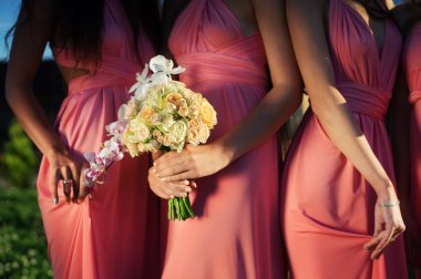 Bridesmaids holding Bouquets of orchids. clipart
