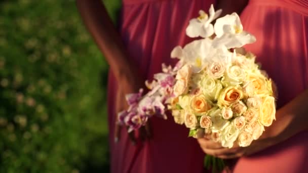 Freundin mit einem Strauß Orchideen und Rosen in den Händen. Nahaufnahme. — Stockvideo