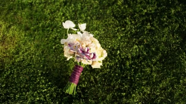 Buquê de casamento de rosas e orquídeas em um belo gramado verde . — Vídeo de Stock