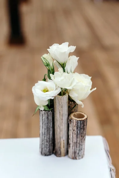 Hermosa decoración en la boda. Arreglo de flores blancas, en jarrones de caña. Primer plano — Foto de Stock