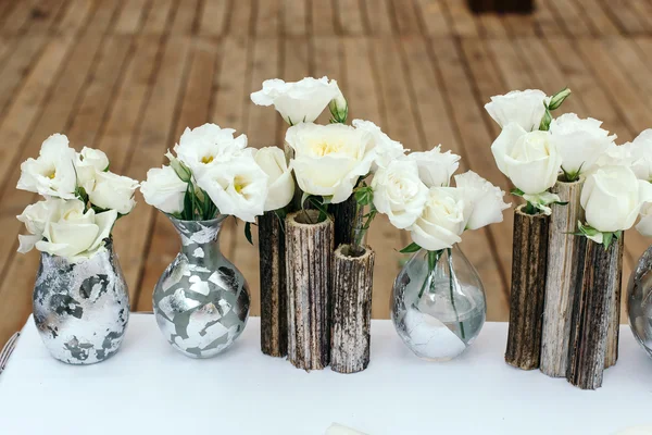 Bela decoração no casamento. Arranjo de flores brancas, em vasos juncos. No chão de madeira de fundo . — Fotografia de Stock