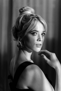 Siyah bluzlu güzel bir sarışının stüdyo portresini kapat ve kameraya bak..